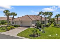 Single-story home with tile roof, two-car garage, and landscaped yard at 13064 Creekside Ln, Port Charlotte, FL 33953