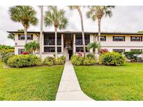 Two-story condo building with lush landscaping and walkway at 1515 Forrest Nelson Blvd # H108, Port Charlotte, FL 33952