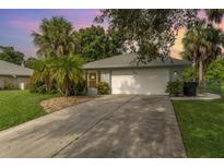 House exterior at sunset, featuring a white garage door and landscaping at 2931 S Cranberry Blvd, North Port, FL 34286