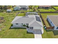 A captivating aerial view of a home featuring solar panels, screened-in lanai, and lush landscaping at 17341 Sabrina Cir, Port Charlotte, FL 33948