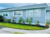 Quaint light-blue house with a well-maintained lawn and sidewalk at 14300 Worthwhile Rd, Port Charlotte, FL 33953