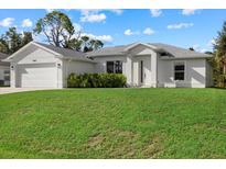 Newly built home with a two car garage and lush lawn at 8450 Malcolm Ave, North Port, FL 34287