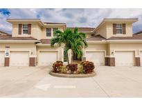 Tan colored townhouses with attached garages and landscaping at 17084 Acapulco Rd # 222, Punta Gorda, FL 33955