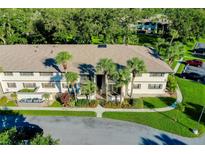 Two-story building exterior with landscaping and palm trees at 1515 Forrest Nelson Blvd # G102, Port Charlotte, FL 33952