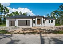 New construction home with a modern design and attached garage at 2502 Pinewood St, North Port, FL 34288