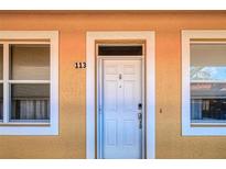 Condo building exterior with white door and tan walls at 3228 Purple Martin Dr # 113, Punta Gorda, FL 33950