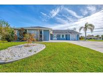 Single story home with light blue exterior and landscaping at 4258 Swensson St, Port Charlotte, FL 33948