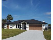 Newly built home with a brown garage door and landscaped lawn at 509 Clearview Dr, Port Charlotte, FL 33953