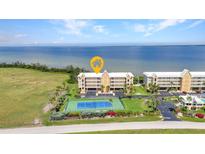 Beautiful waterfront condo complex with a tennis court and manicured landscaping at 101 N Marion Ct # 122, Punta Gorda, FL 33950