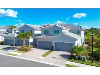 Three attached townhouses with grey exterior and two-car garages at 14640 Sycamore Ct # 2822, Punta Gorda, FL 33955