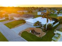 Aerial view of a single-Gathering home with a landscaped yard and driveway at 91 Mark Twain Ln, Rotonda West, FL 33947