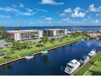 An aerial view of waterfront property with boat slips and a condo building at 25188 Marion Ave # E301, Punta Gorda, FL 33950