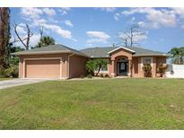 Attractive single-story house with a two-car garage and landscaped lawn at 1858 Norvell Ave, North Port, FL 34286