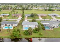 Bright aerial view of a charming single-Gathering home featuring a private backyard pool and lush landscaping at 25 Caddy Rd, Rotonda West, FL 33947
