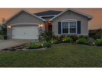 One-story house with a white garage door, landscaping, and a walkway at 7093 Mikasa Dr, Punta Gorda, FL 33950