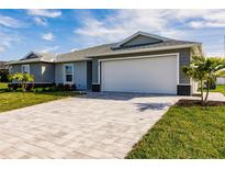 New construction home with gray siding, white garage door, and paved driveway at 25118 Alcazar Dr, Punta Gorda, FL 33955