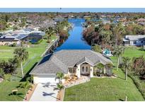 Single-Gathering home on canal with fenced yard, driveway, and lush landscaping at 18404 Lake Worth Blvd, Port Charlotte, FL 33948