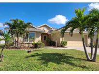 Tan one-story house with attached garage, palm trees, and well-manicured lawn at 124 Jennifer Dr, Rotonda West, FL 33947