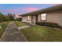 Exterior of a light-colored house with walkway and landscaping at dusk at 25068 Harborview Rd # 2A, Punta Gorda, FL 33980