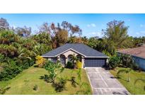 Charming single-story home with a well-maintained lawn, inviting curb appeal, and an attached two-car garage at 3316 Kacher Rd, North Port, FL 34288