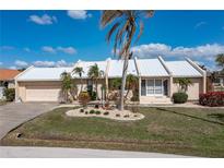 Single-story home with a metal roof, landscaped yard, and attached garage at 3636 Aruba Ct, Punta Gorda, FL 33950