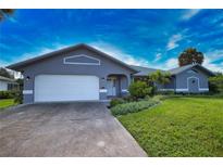 Gray house with white garage door and landscaping at 1256 Alton Rd, Port Charlotte, FL 33952