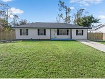Newly renovated home with a white exterior and black accents at 18289 Eblis Ave, Port Charlotte, FL 33948