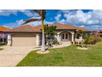 Beautiful two-story home with tile roof, lush landscaping and paved driveway at 2736 Magdalina Dr, Punta Gorda, FL 33950