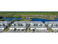 Aerial view of a row of townhouses with attached garages near a lake at 14271 Heritage Landing Blvd # 1526, Punta Gorda, FL 33955
