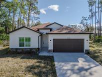 One-story home with brown garage door and light colored siding at 3802 Eagle Pass St, North Port, FL 34286