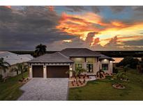 Luxury waterfront home with a three-car garage and scenic sunset views at 5179 Collingswood Blvd, Port Charlotte, FL 33948