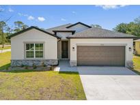 A charming home with a gray roof, neutral siding, and a well-manicured front lawn at 1100 S Wapello St, North Port, FL 34286