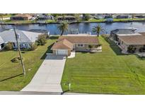 Charming waterfront home with a well-manicured lawn, dock, and long driveway at 201 W Tarpon Nw Blvd, Port Charlotte, FL 33952