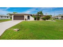 Single-story home with a large front yard, attached garage, and mature landscaping at 3545 Syracuse St, Port Charlotte, FL 33952