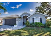 Charming single-story home featuring a well-maintained lawn, arched entryway, and attached garage at 5255 Drew Rd, Venice, FL 34293