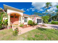 Charming home with a pink facade, columns at the entrance, and a well-maintained lawn at 3646 Madagascar Ave, North Port, FL 34286