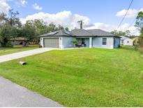 Charming single-story house with a green lawn and driveway at 4340 Adolph Ave, North Port, FL 34288