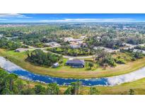 An aerial view showcasing a house, pool, and lush landscape at 8194 Sawyer Cir, North Port, FL 34288