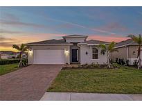Two-story house with gray exterior, brick driveway, and landscaped lawn at 16138 Highgate St, Port Charlotte, FL 33953