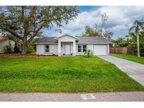 Newly built home with a well-manicured lawn and driveway at 2190 Taunt St, Port Charlotte, FL 33948