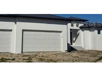 Three-car garage and front entrance of a new construction home at 24092 Potosi Ct, Punta Gorda, FL 33955