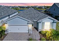 Attractive single-story home with light blue exterior, two-car garage, and landscaped yard at 43015 Parkside Ct, Punta Gorda, FL 33982