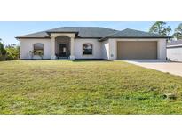 Single-story house with a two-car garage and a large grassy yard at 12333 Willmington Blvd, Port Charlotte, FL 33981