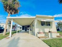 Charming single-story home featuring a covered carport, awning-shaded window, and a well-maintained lawn at 207 Blackburn Blvd, North Port, FL 34287