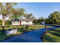Charming home exterior with a long driveway and a rustic fence at 1010 Robinhood Dr, Punta Gorda, FL 33982