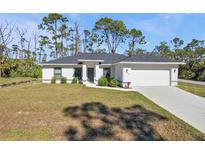 Single-story home with a gray roof and white exterior, featuring a two-car garage at 17494 Iago Ave, Port Charlotte, FL 33954