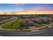 Aerial view of a single-Gathering home in a residential community with a lake at 8533 Peregrine Way, North Port, FL 34287