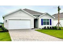 Charming single-story home showcasing a paved driveway, well-manicured lawn, and neutral-tone facade at 9531 Turtle Grass Cir, Punta Gorda, FL 33950