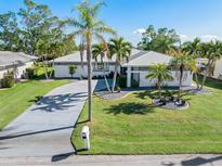 Single-story home with metal roof, palm trees, and landscaped yard at 3014 Guadalupe Dr, Punta Gorda, FL 33950