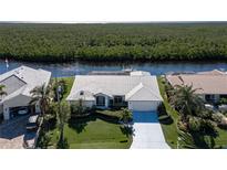 Aerial view of waterfront home with private dock and lush landscaping at 3936 Crooked Island Dr, Punta Gorda, FL 33950